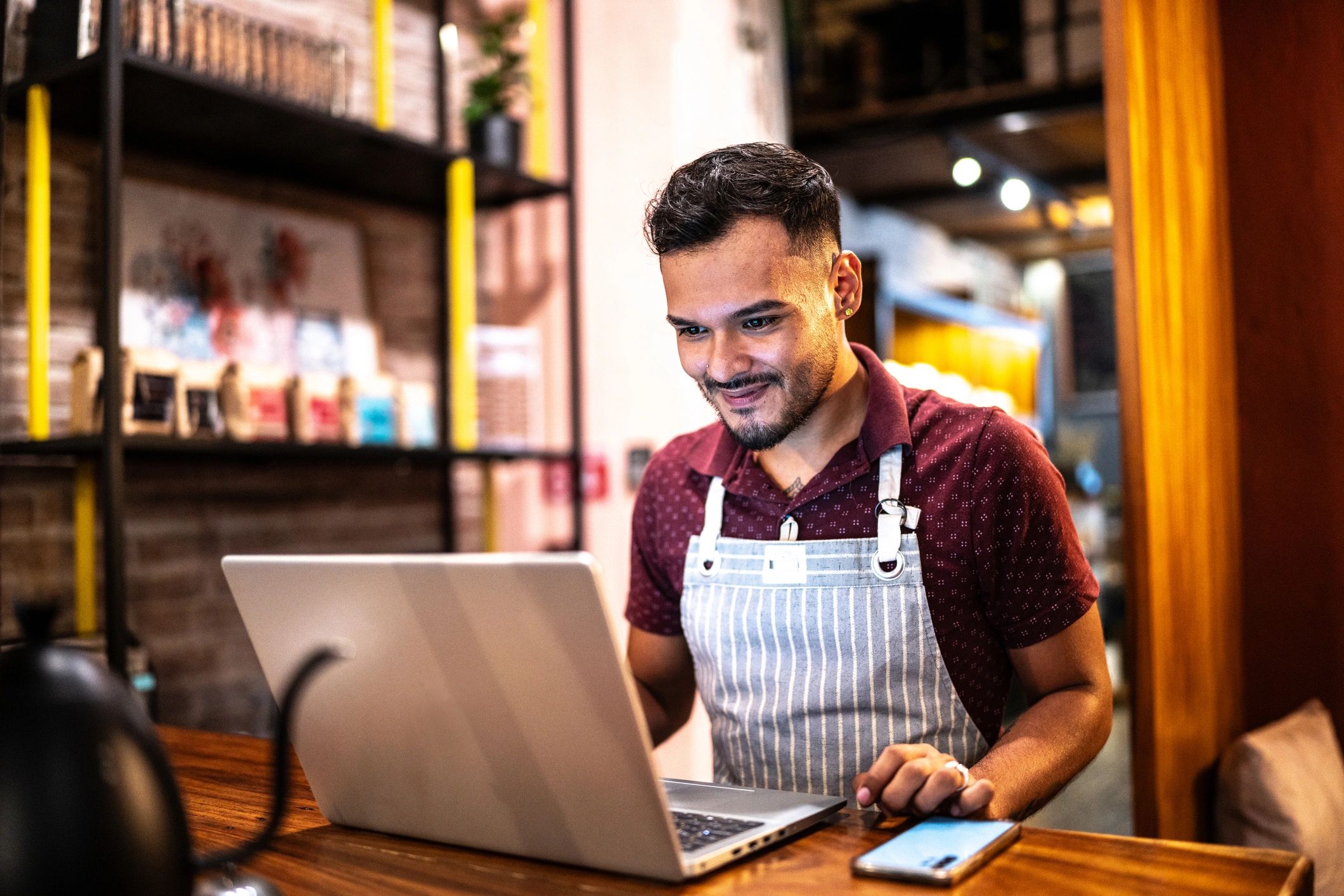 Small business owner using a laptop at a coffee shop