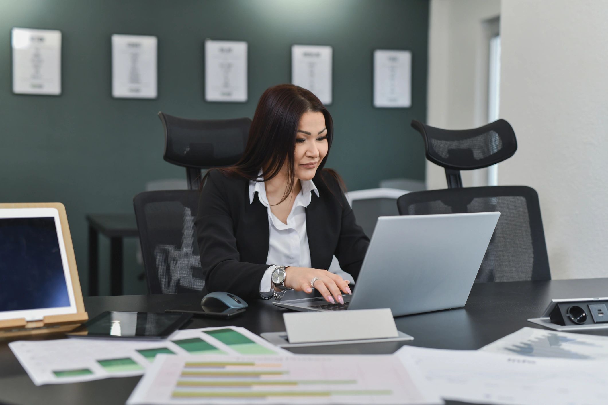 Bookkeeper reviewing documents while working on a laptop
