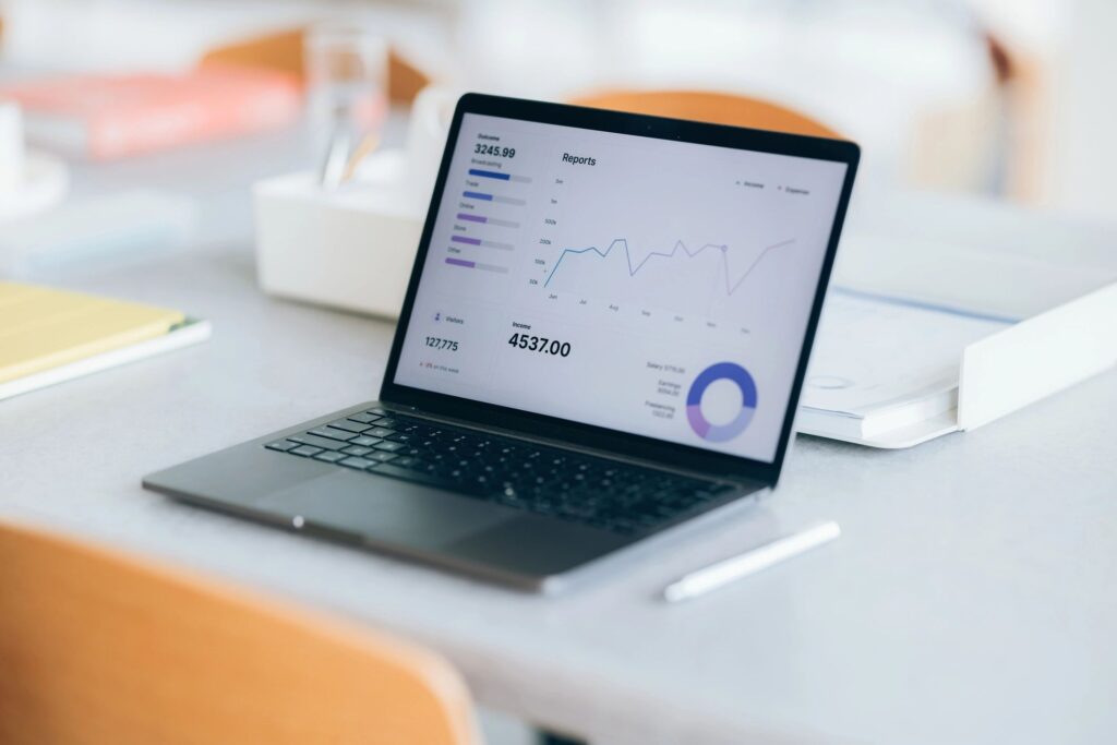 Laptop displaying financial reports and charts on a desk