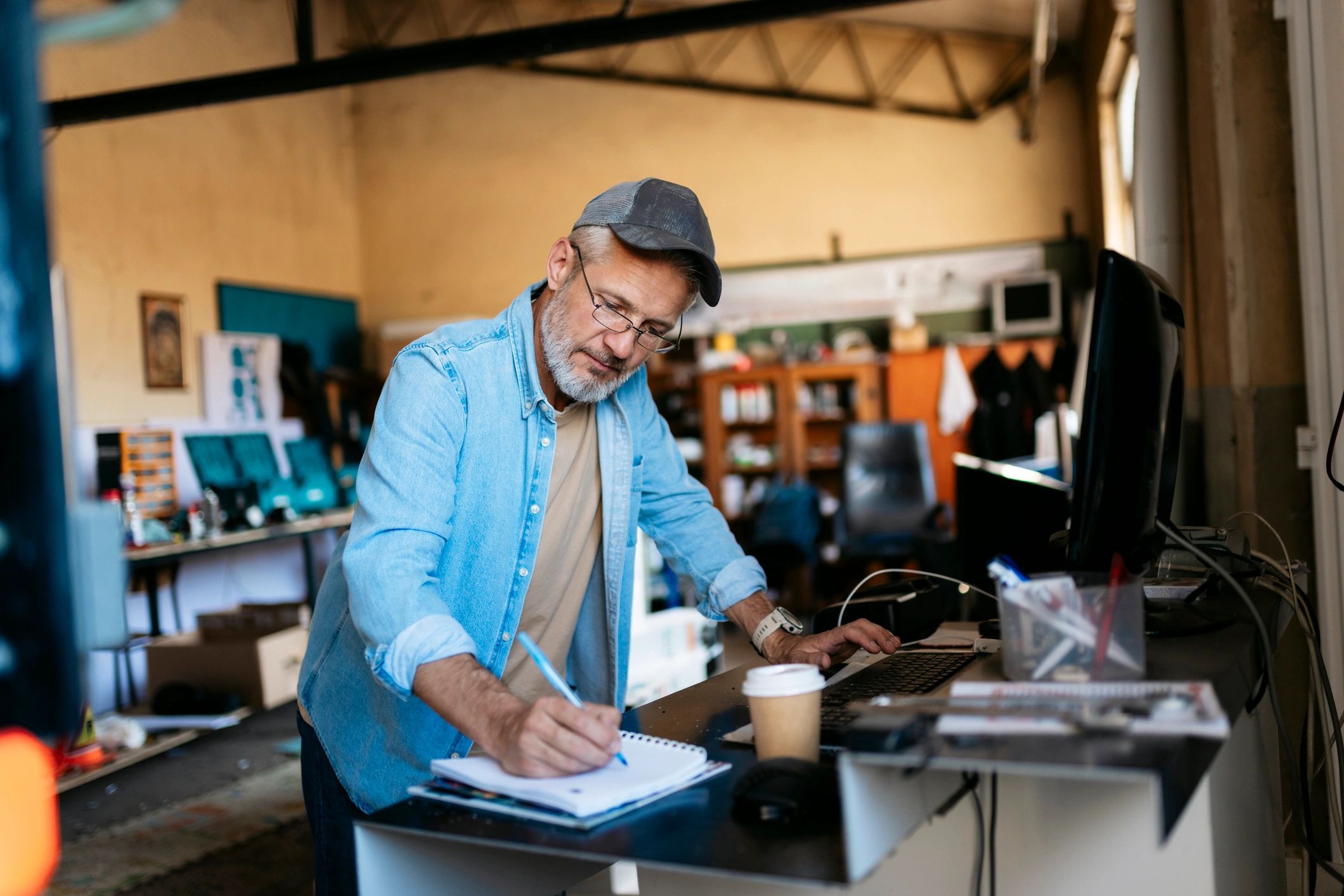 Entrepreneur writing notes while using a computer
